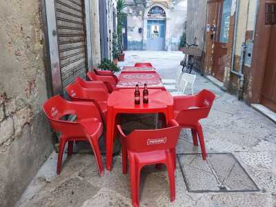 Qui l�aria di autenticit� si respira fin da subito: la viuzza � piena di tavoli non apparecchiati e sedie rosse marcate Peroni...